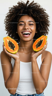 Joyful Woman with Fresh Papaya Halves Against Bright Background