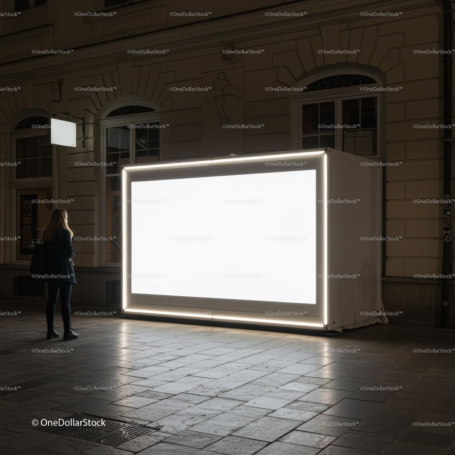 Kobieta obserwuje oświetlony miejski billboard nocą