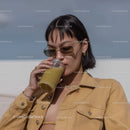 Fashionable Woman Drinking Green Smoothie Outdoors With Sunglasses