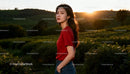 Young woman standing in lush field during sunset