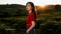 Young woman standing in lush field during sunset