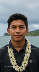 Young Man Wearing Floral Lei Against Tropical Island Landscape