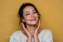 Smiling Woman with Radiant Skin Under Beige Light
