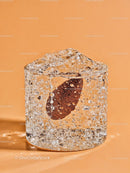Close Up of Clear Ice Cube with Bubble and Orange Seed