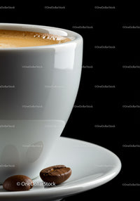 Close up of espresso cup with coffee beans on saucer