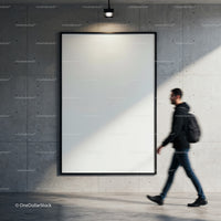 Blurred man walking past blank poster on concrete wall