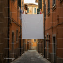 Narrow cobblestone alley with laundry and shutters