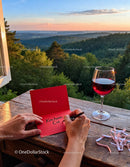 Writing a love note with wine at sunset in nature