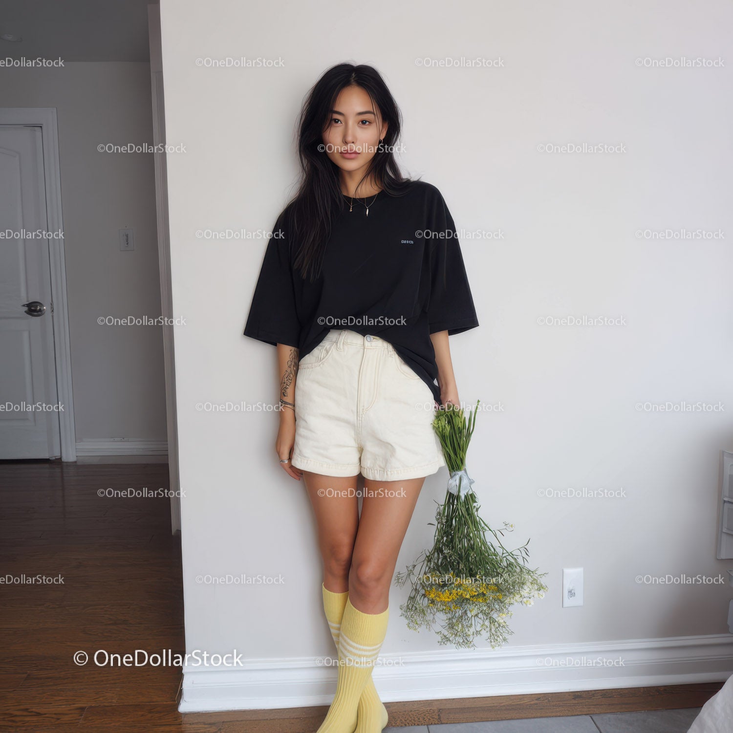 Young Woman in Black Oversized T-Shirt and Beige Shorts Holding Flowers
