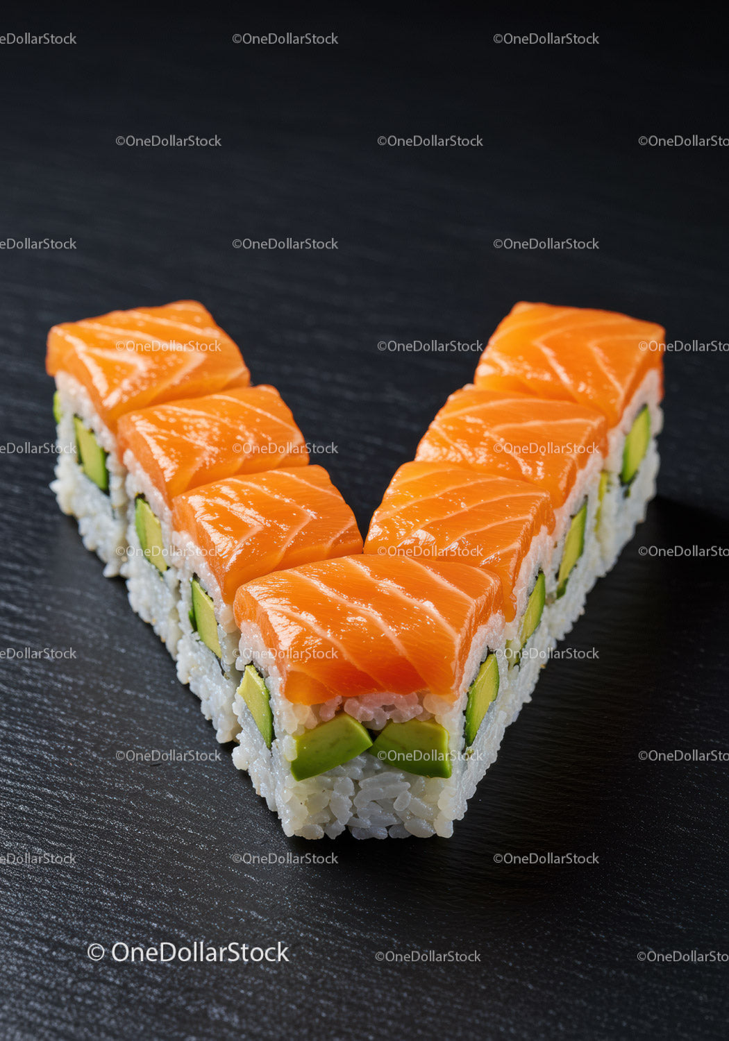 Świeże rolki sushi z łososiem i awokado ułożone w kształcie litery V