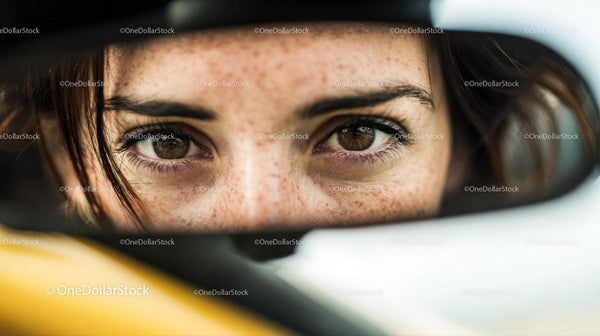 Close-up of Brown-eyed Woman with Freckles Reflecting in Car Mirror