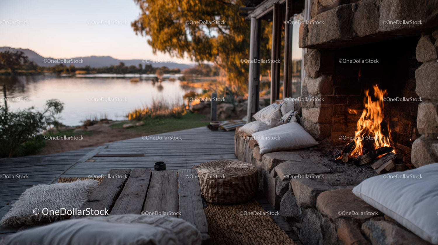 Cozy Lakeside Outdoor Fireplace Scene with Cushions and Scenic View