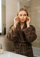 Young Woman Applying Gold Under Eye Patches in Bathroom