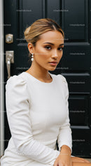 Elegant woman with pearl earrings in white dress
