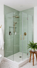 Modern glass shower with green subway tile walls