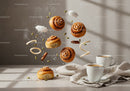 Fresh cinnamon rolls with coffee and floating ingredients