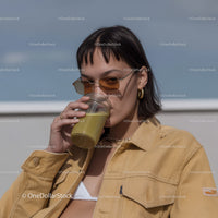Stylish Young Woman Drinking Green Juice on Urban Terrace