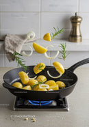 Fresh potatoes and herbs tossed in skillet over stove flame