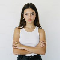 Confident Young Woman in White Tank Top with Crossed Arms