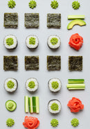 Minimalist sushi and fresh vegetable arrangement on white