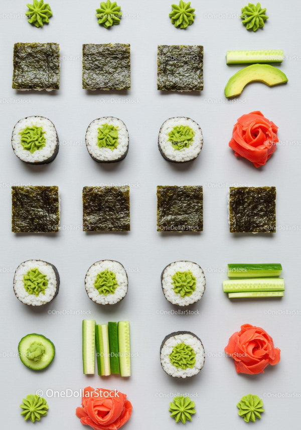 Minimalist sushi and fresh vegetable arrangement on white
