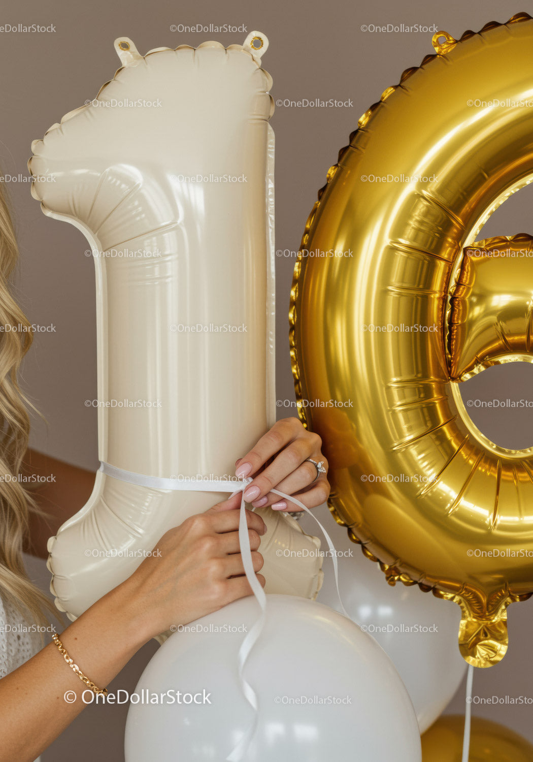 Close up on hands holding 16th birthday balloons