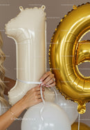 Close up on hands holding 16th birthday balloons