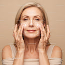 Elegant Mature Woman Applying Facial Cream for Healthy Skin