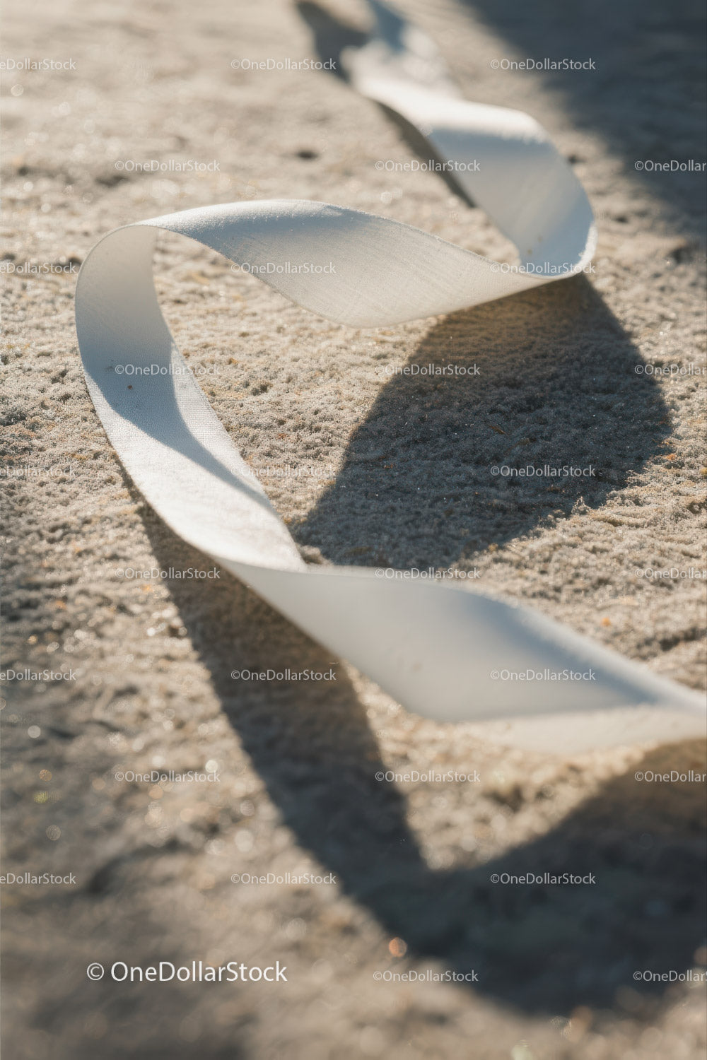 Close-up of White Plastic Ribbon Waste on Sandy Beach