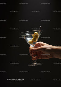 Hand Holding Martini Glass with Olive Garnish