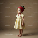 Little girl in yellow dress wearing strawberry hat