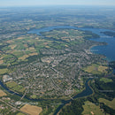 Aerial View of a Town with Parks and Water Bodies Surrounding Green Fields