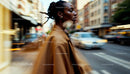 Chic Woman in Brown Coat Walking Through Busy City Street