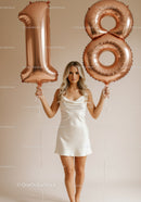 Young woman celebrating 18th birthday with balloons