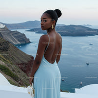 Elegant woman in blue dress overlooking sea cliff view