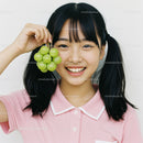 Happy Young Girl Holding Fresh Green Grapes in Casual Pink Polo