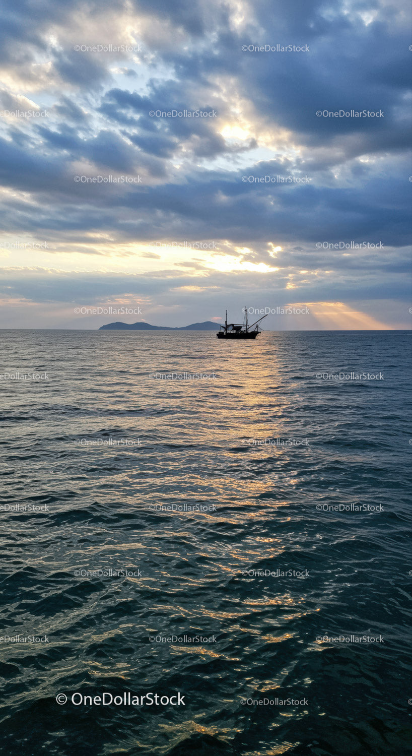 Serene Sunset Over Ocean with Sailing Boat and Cloudy Sky