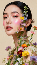 Elegant woman with glowing makeup surrounded by wildflowers