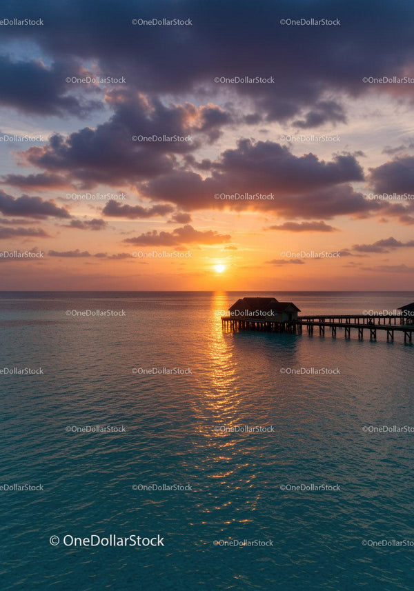 Tranquil Sunset Over Ocean with Overwater Bungalows and Cloudy Sky