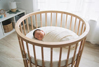 Peaceful newborn wrapped warmly in modern crib