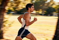 Young man running briskly in warm sunlight park
