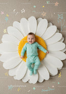 Happy baby lying on giant daisy flower prop