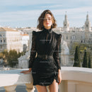 Elegant Young Woman in Black Dress on Rooftop Balcony Against City Skyline