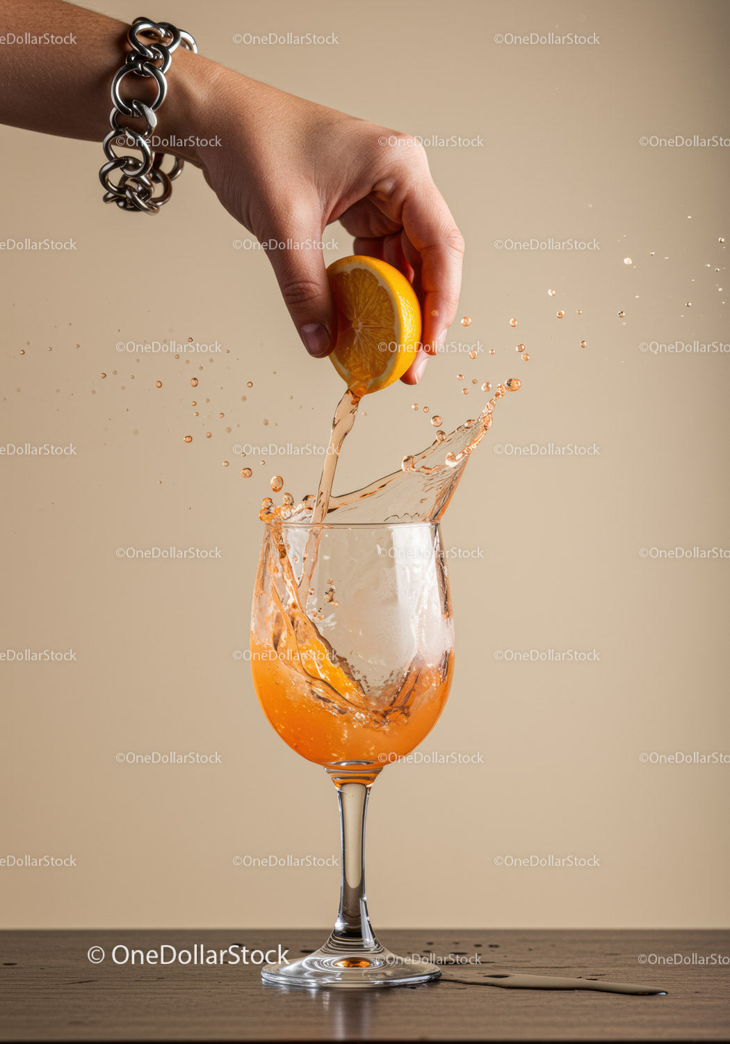 Hand Squeezing Fresh Lemon Into Splashing Drink Glass
