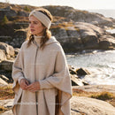 Woman in cozy knitwear enjoying seaside autumn breeze