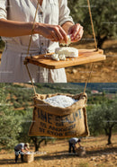 Hands Crumbling Fresh Cheese on Rustic Wooden Board