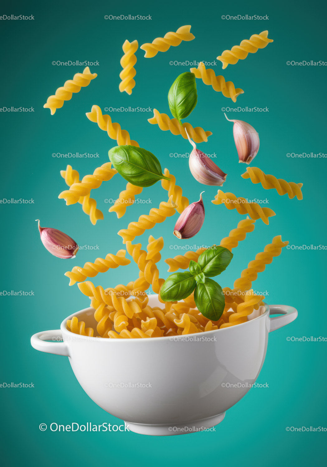 Spiral pasta with fresh basil and garlic cloves flying