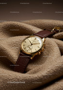 Elegant Gold Wristwatch with Leather Strap on Beige Fabric