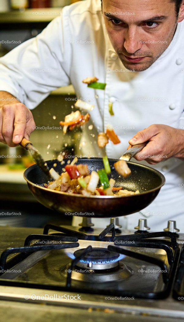 Chef Tossing Stir-Fry Vegetables Over Gas Stove