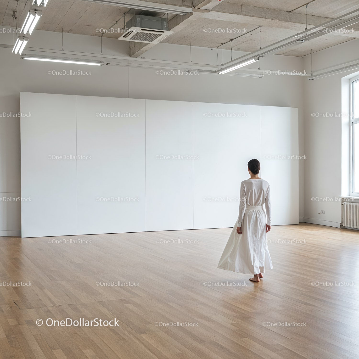 Kobieta w białej sukni spacerująca po minimalistycznej galerii sztuki